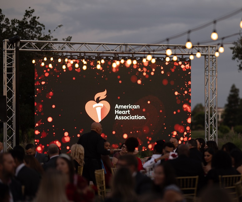 Photo of stage backdrop with American Heart Association heart and torch logo.